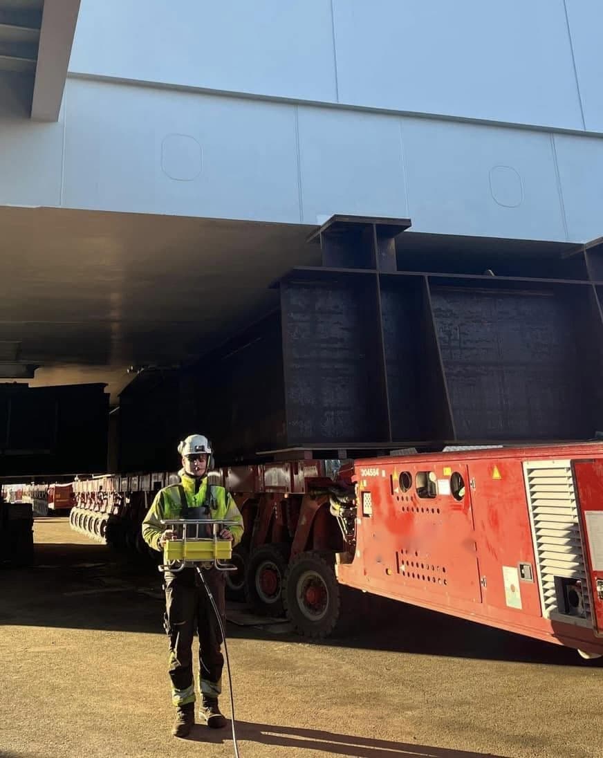 Nicolay Karlgård i verneutstyr på et industrianlegg, med fjernkontroll til en tungtransportvogn